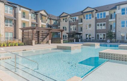 Swimming pool with seating and view of apartment building